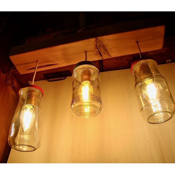 Peque&ntilde;a l&aacute;mpara de ara&ntilde;a con tarros reciclados y madera.