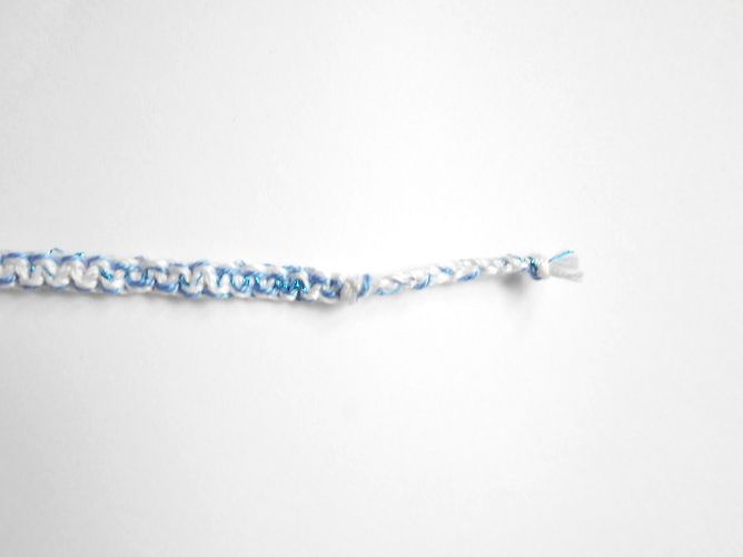 Bracelet en macramé plat 4 fils, coloris blanc et bleuet, aspect satiné, relevé d’un fil lurex très fin bleu métallisé