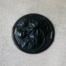Medallón de nenúfar en relieve de metal negro con lazos laterales 
