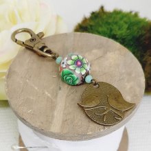 medalla llavero dúo de pájaros color bronce y perla artesanal motivo floral verde y vino líasmulticolor