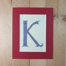 Letra K iluminada con entrelazado