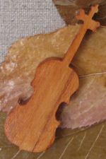 Pequeño violín de madera sobre un lecho de hojas