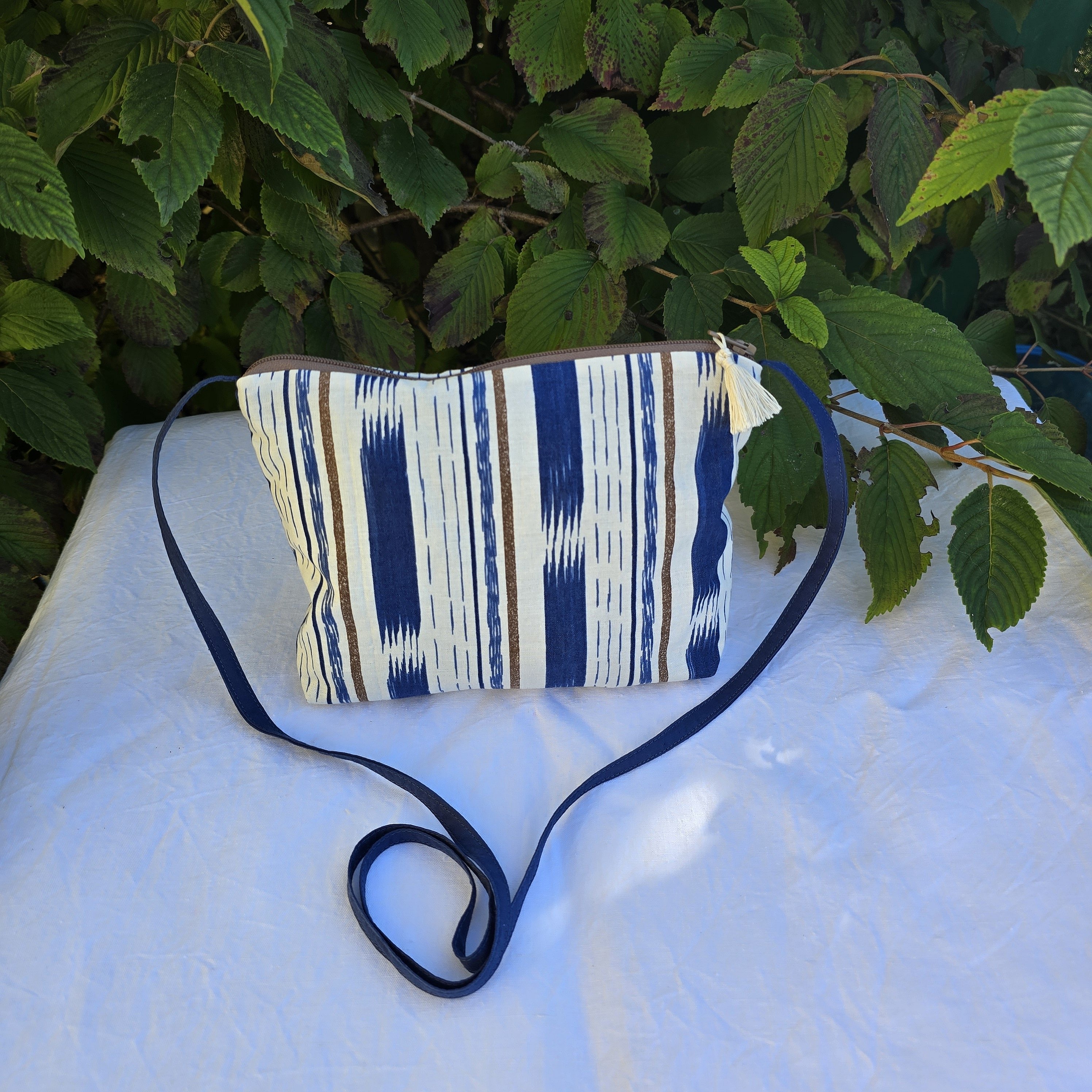 Pochette avec bandouli&egrave;re en tissu coton bleu et marron agr&eacute;ment&eacute;e d'un pompon