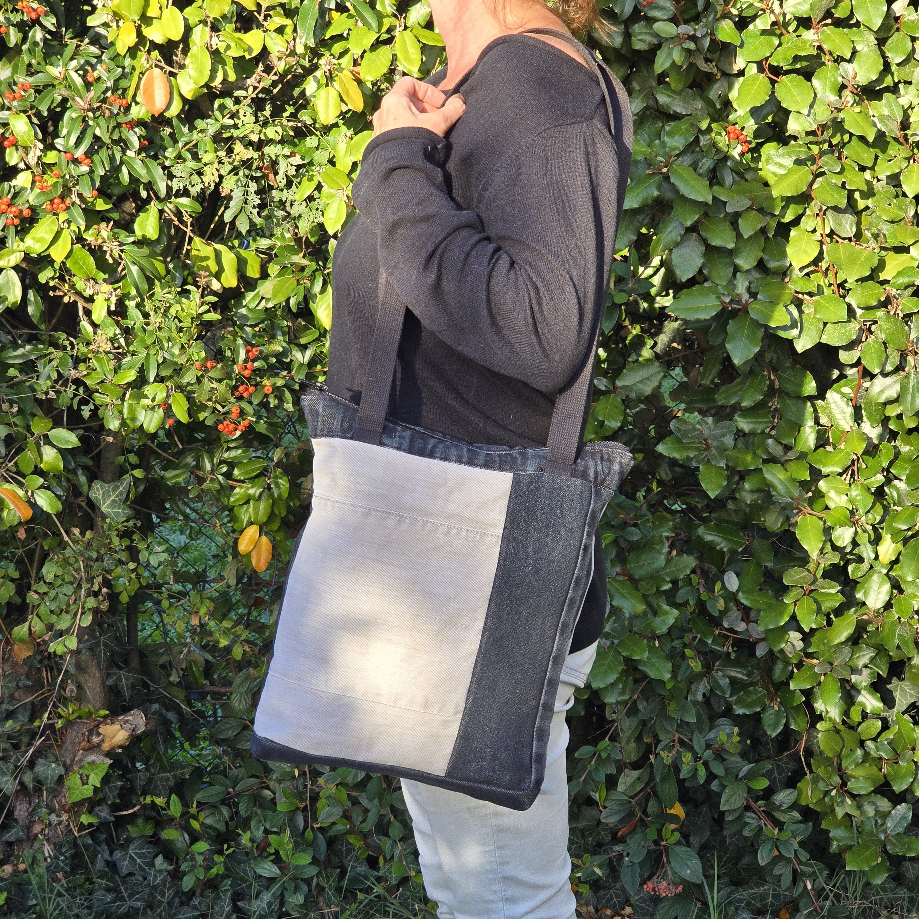 Sac à bandoulière en jean recyclé noir et gris avec empiècements.