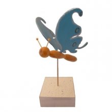 Mariposa azul eléctrico en una escultura de madera de pie