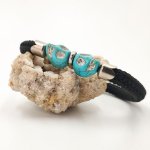 Pulsera de cuerda negra con doble calavera en piedras azules