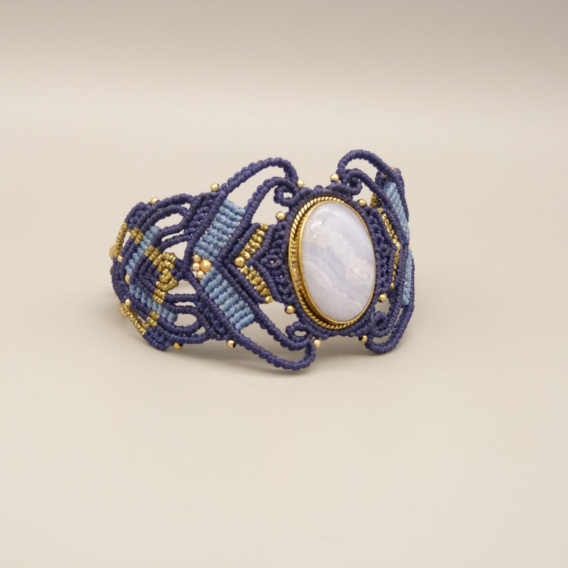 Pulsera de micromacramé azul noche con una cinta de ágata engastada en metal dorado