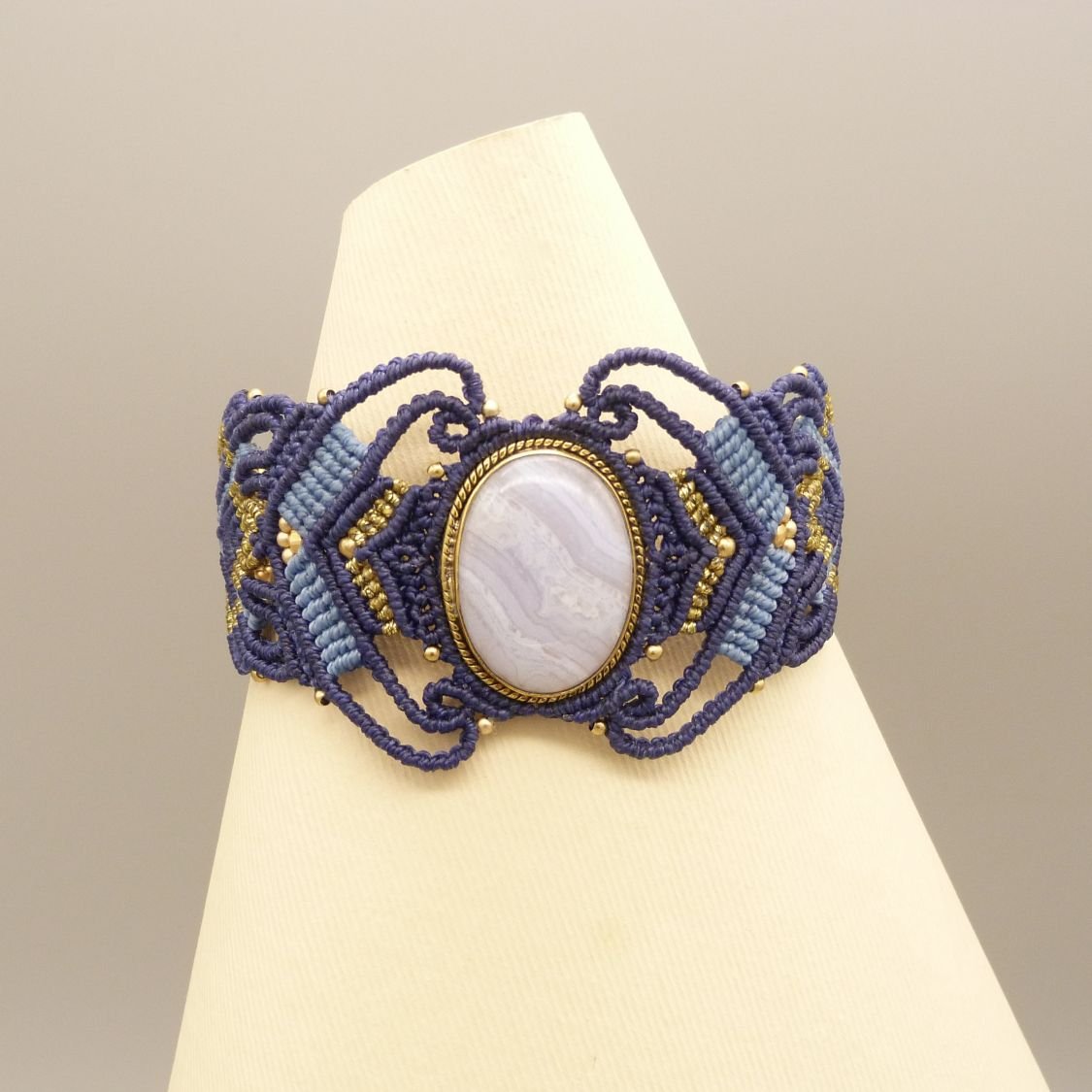 Pulsera de micromacramé azul noche con una cinta de ágata engastada en metal dorado