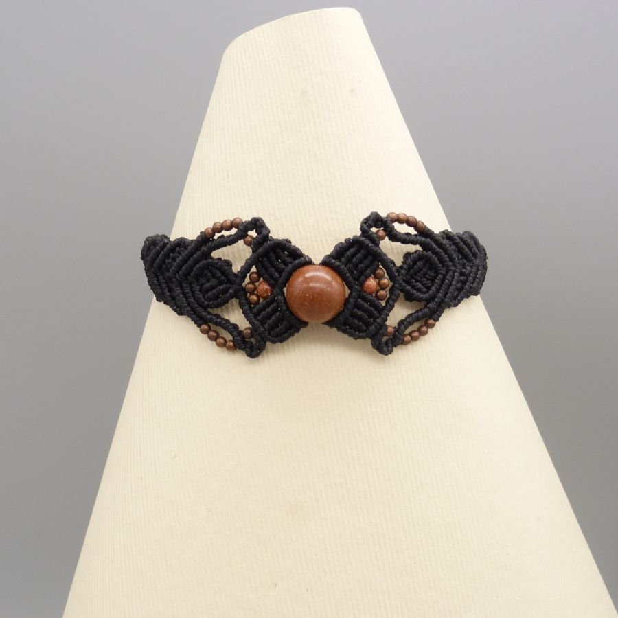 Pulsera de micromacramé negro con una cuenta central de "piedra solar