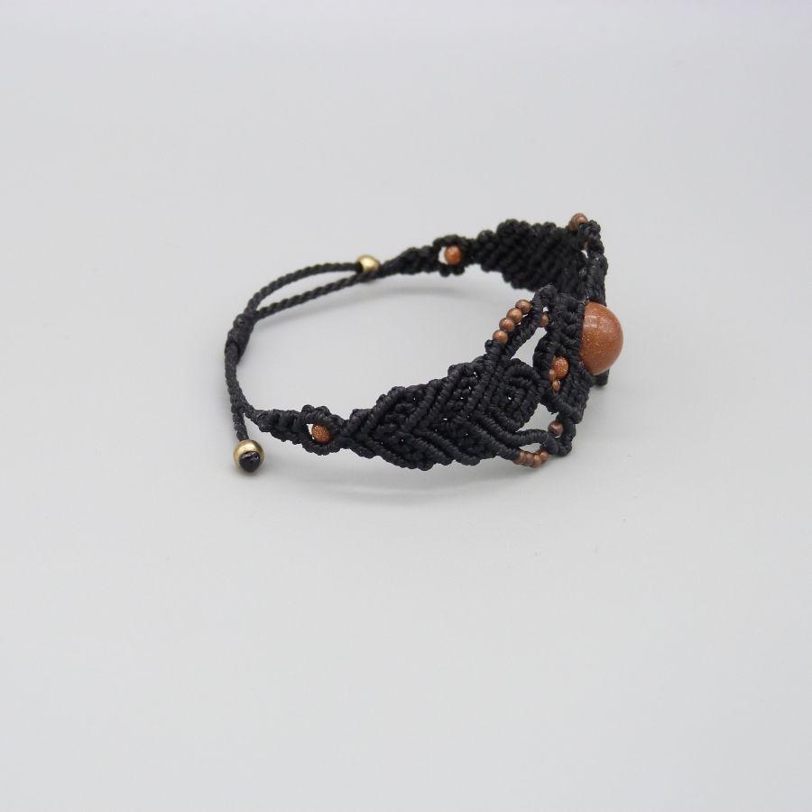 Pulsera de micromacramé negro con una cuenta central de "piedra solar