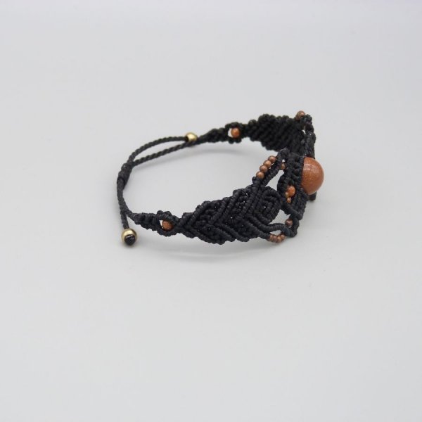 Pulsera de micromacram&eacute; negro con una cuenta central de "piedra solar