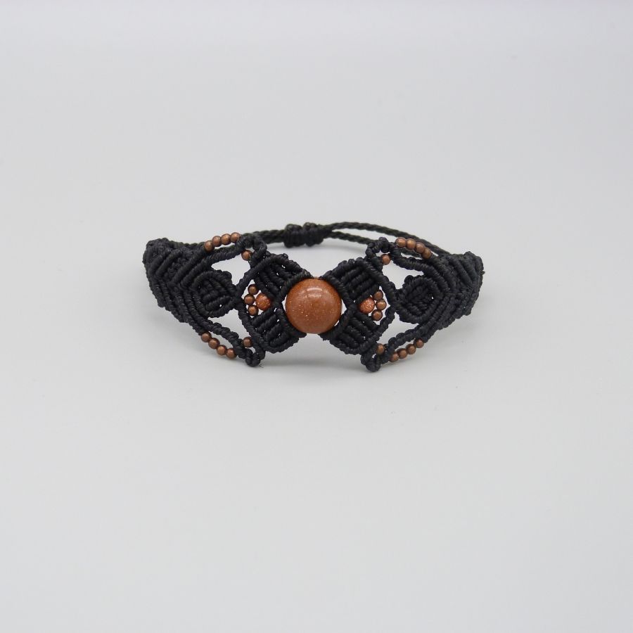 Pulsera de micromacramé negro con una cuenta central de "piedra solar