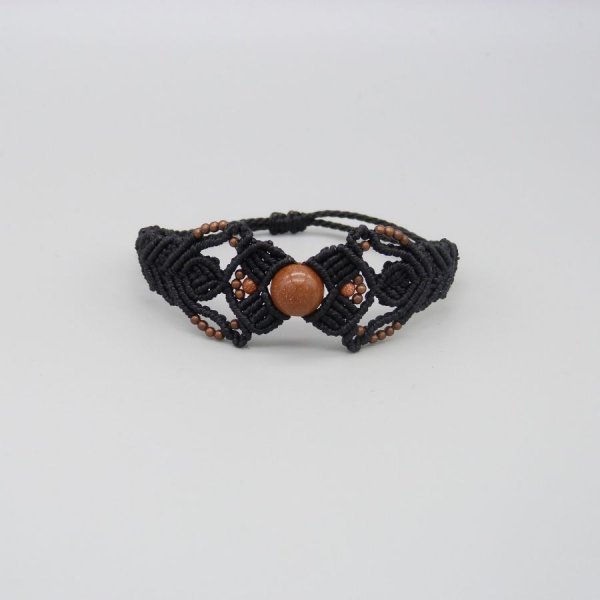 Pulsera de micromacram&eacute; negro con una cuenta central de "piedra solar