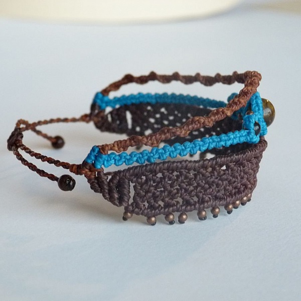 Bracelet en macramé marron et bleu avec perles décoratives.