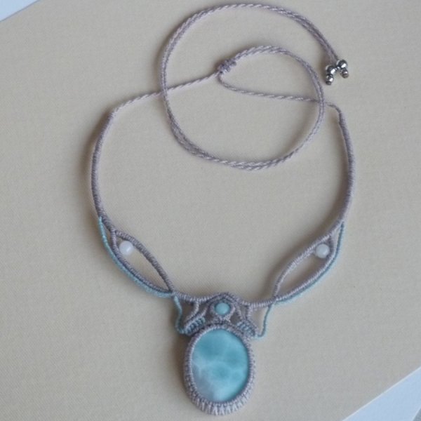 Collar de micromacram&eacute; gris topo/azul esmerilado con una gema natural en tonos suaves de blanco y azul claro como pieza central.