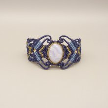 Pulsera de micromacramé azul noche con una cinta de ágata engastada en metal dorado