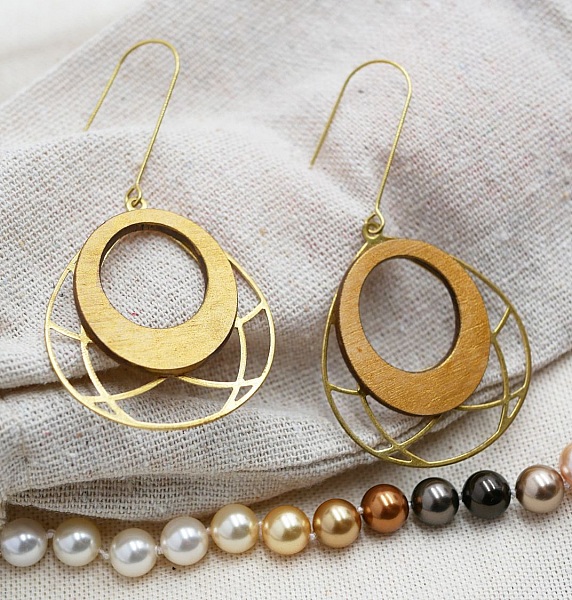 Pendientes ovalados de madera dorada sobre borla de lat&oacute;n calada