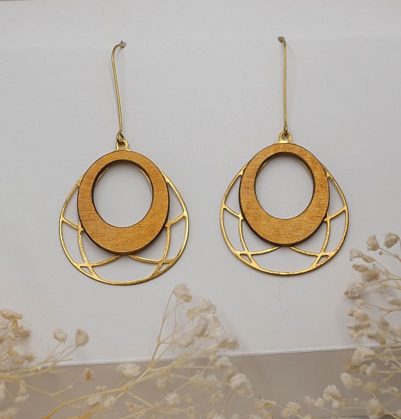 Pendientes ovalados de madera dorada sobre borla de lat&oacute;n calada