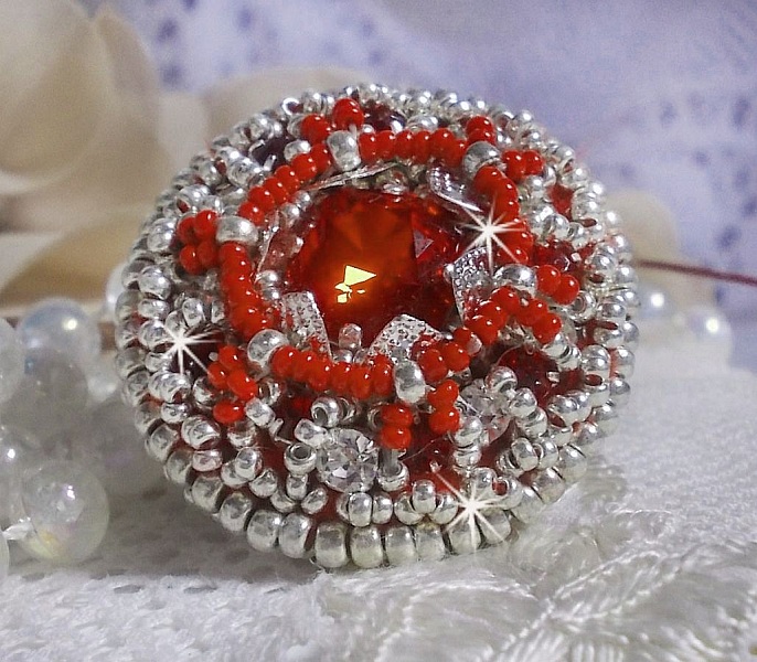 Anillo Drigon Red bordado con un cabuj&oacute;n de cristal de Swarovski rojo, biseles de plata y cuentas de rocalla