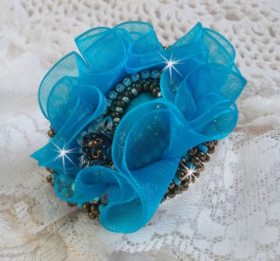 Ilycia Anillo con encanto bordado con un cabujón facetado de resina azul turquesa y una cinta de organza