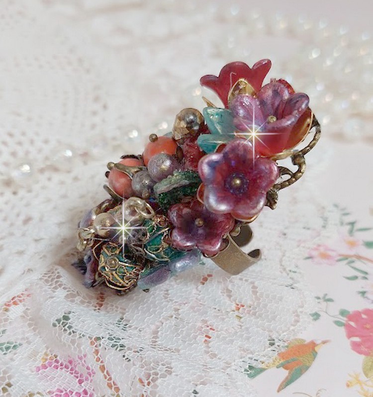 Bague Onia pour une composition florale créée avec des cristaux, fleurs : perles, clochettes, pensées, gouttes Druzy,  pierre de gemme : le Corail, perles cloisonnées et bague ovale en Laiton