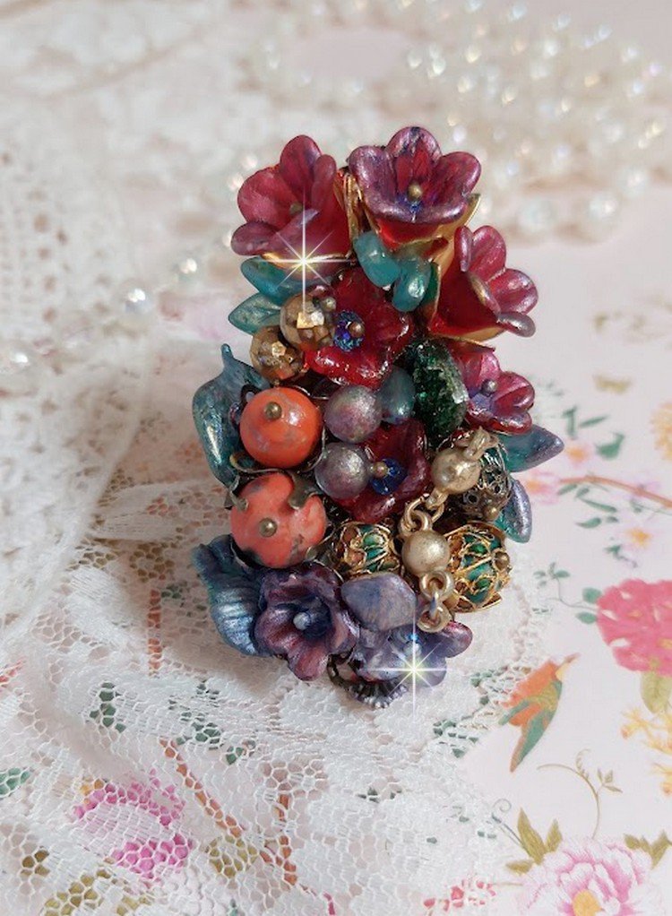 Bague Onia pour une composition florale créée avec des cristaux, fleurs : perles, clochettes, pensées, gouttes Druzy,  pierre de gemme : le Corail, perles cloisonnées et bague ovale en Laiton