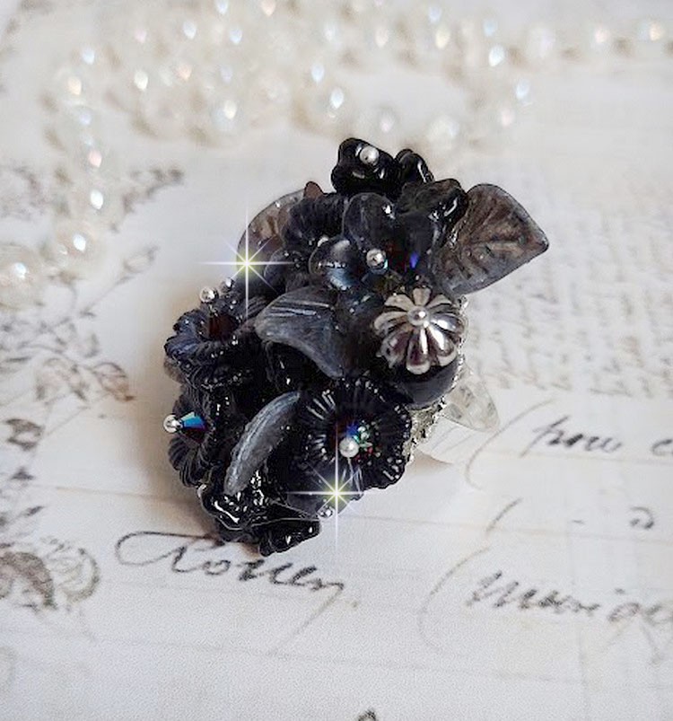 Bague Soir de Lune créée avec des fleurs lucites Noires et Grises peintes à la main, cristaux, perles en résine, perles en verre et coupelle argentée. Le tout est monté sur une bague argentée