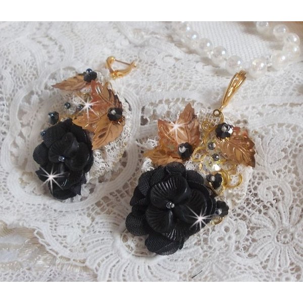 Atrapasue&ntilde;os negro y dorado ondulado bordado con cristales de Swarovski, flores de tela y cuentas de semillas.