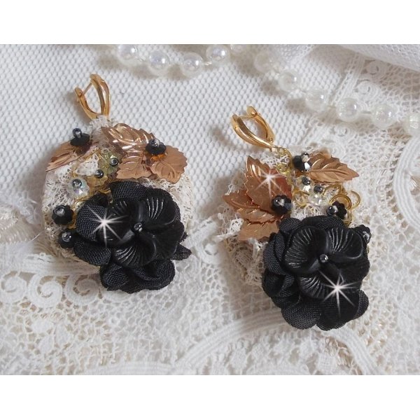 Atrapasue&ntilde;os negro y dorado ondulado bordado con cristales de Swarovski, flores de tela y cuentas de semillas.