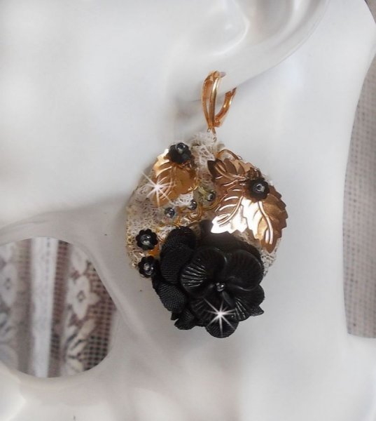 Atrapasue&ntilde;os negro y dorado ondulado bordado con cristales de Swarovski, flores de tela y cuentas de semillas.