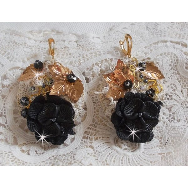 Atrapasue&ntilde;os negro y dorado ondulado bordado con cristales de Swarovski, flores de tela y cuentas de semillas.