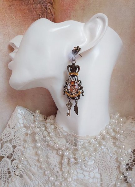 BO Chatibo Steampunk mont&eacute;es avec cabochons ronds en verre repr&eacute;sentant un chat chapeaut&eacute; Haute de Forme Orange. Strass&eacute;es avec une couronne, breloques cl&eacute;s et feuilles. Mont&eacute;es sur clips Bronze