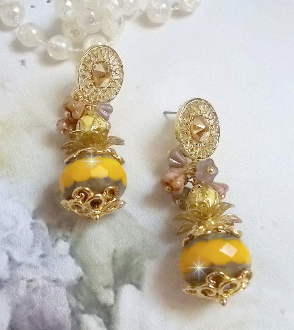 BO Lumière Opale Jaune avec des perles potirons jaunes à laquelle s’ajoute des fleurs, cabochons en cristal, coupelles et perles rondes. Montés sur clous d’oreilles en Métal. Un style moderne