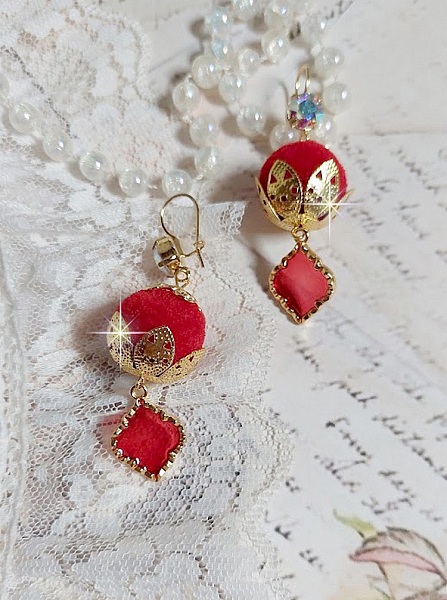 BO Passionn&eacute;ment mont&eacute;es avec des pompons Rouges tr&egrave;s tendances &agrave; laquelle s&rsquo;ajoute des coupelles en forme d&rsquo;arabesque, pendentifs vitrail Rouge/Dor&eacute; et cabochons en Cristal AB sur crochets en Laiton