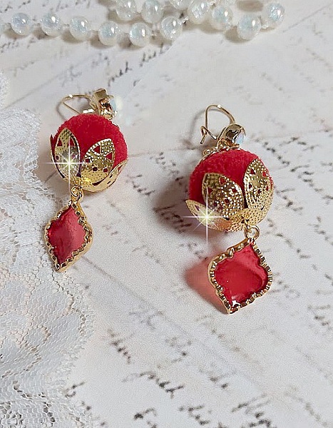 BO Passionn&eacute;ment mont&eacute;es avec des pompons Rouges tr&egrave;s tendances &agrave; laquelle s&rsquo;ajoute des coupelles en forme d&rsquo;arabesque, pendentifs vitrail Rouge/Dor&eacute; et cabochons en Cristal AB sur crochets en Laiton