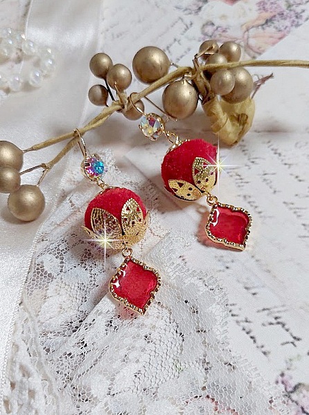 BO Passionn&eacute;ment mont&eacute;es avec des pompons Rouges tr&egrave;s tendances &agrave; laquelle s&rsquo;ajoute des coupelles en forme d&rsquo;arabesque, pendentifs vitrail Rouge/Dor&eacute; et cabochons en Cristal AB sur crochets en Laiton