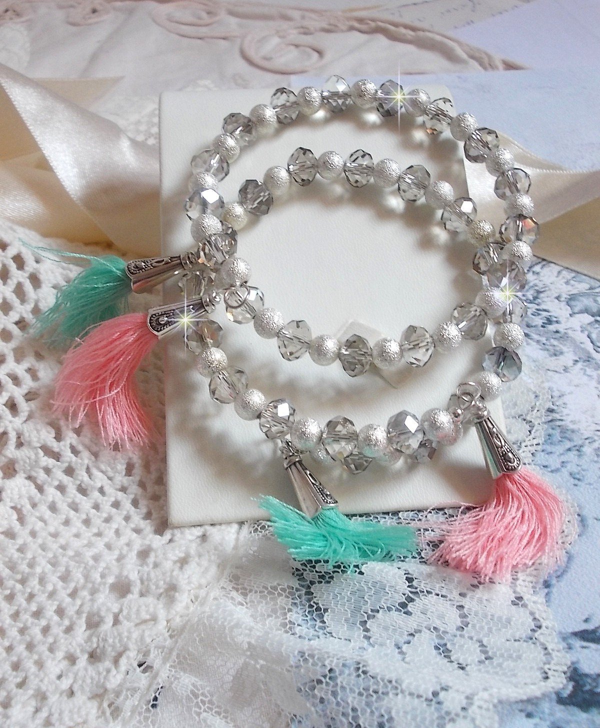 Bracelets Cristalline Eclat avec doubles bracelets aux perles Stardust Argent&eacute;es effet paillet&eacute;, perles rondes facett&eacute;es en verre et pompons couleur Rose et Menthe pour un style contemporain