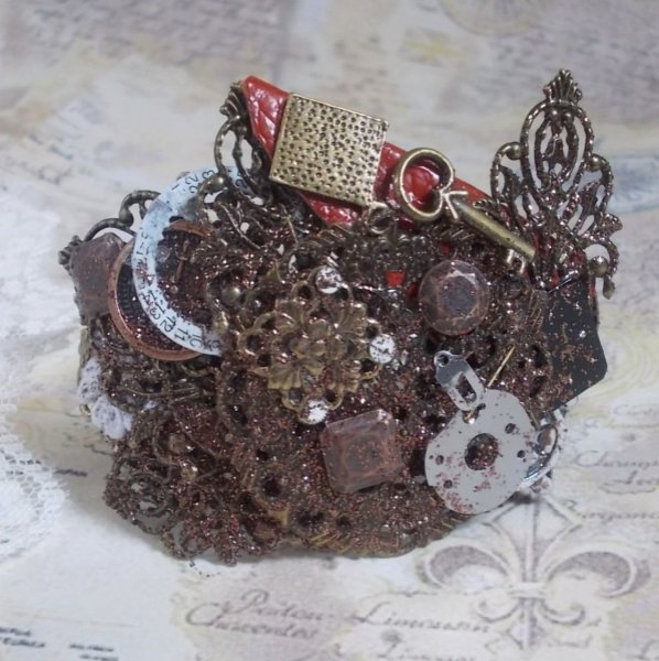 Pulsera Navigating Shadow creada con cuero de color co&ntilde;ac, flor de tela, accesorios de bronce, cobre y negro con charms
