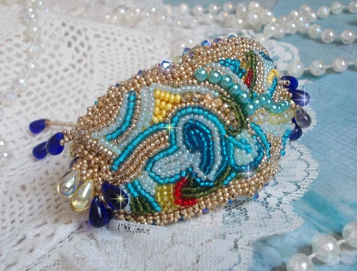 Pulsera Mariposa de Oro Azul bordada con cristales de Swarovski; gotas lisas, facetas, cuentas de semillas y un cierre de Oro Fino de 14 quilates