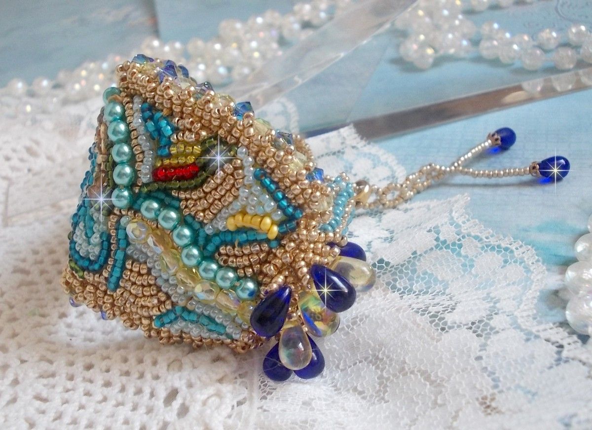 Pulsera Mariposa de Oro Azul bordada con cristales de Swarovski; gotas lisas, facetas, cuentas de semillas y un cierre de Oro Fino de 14 quilates