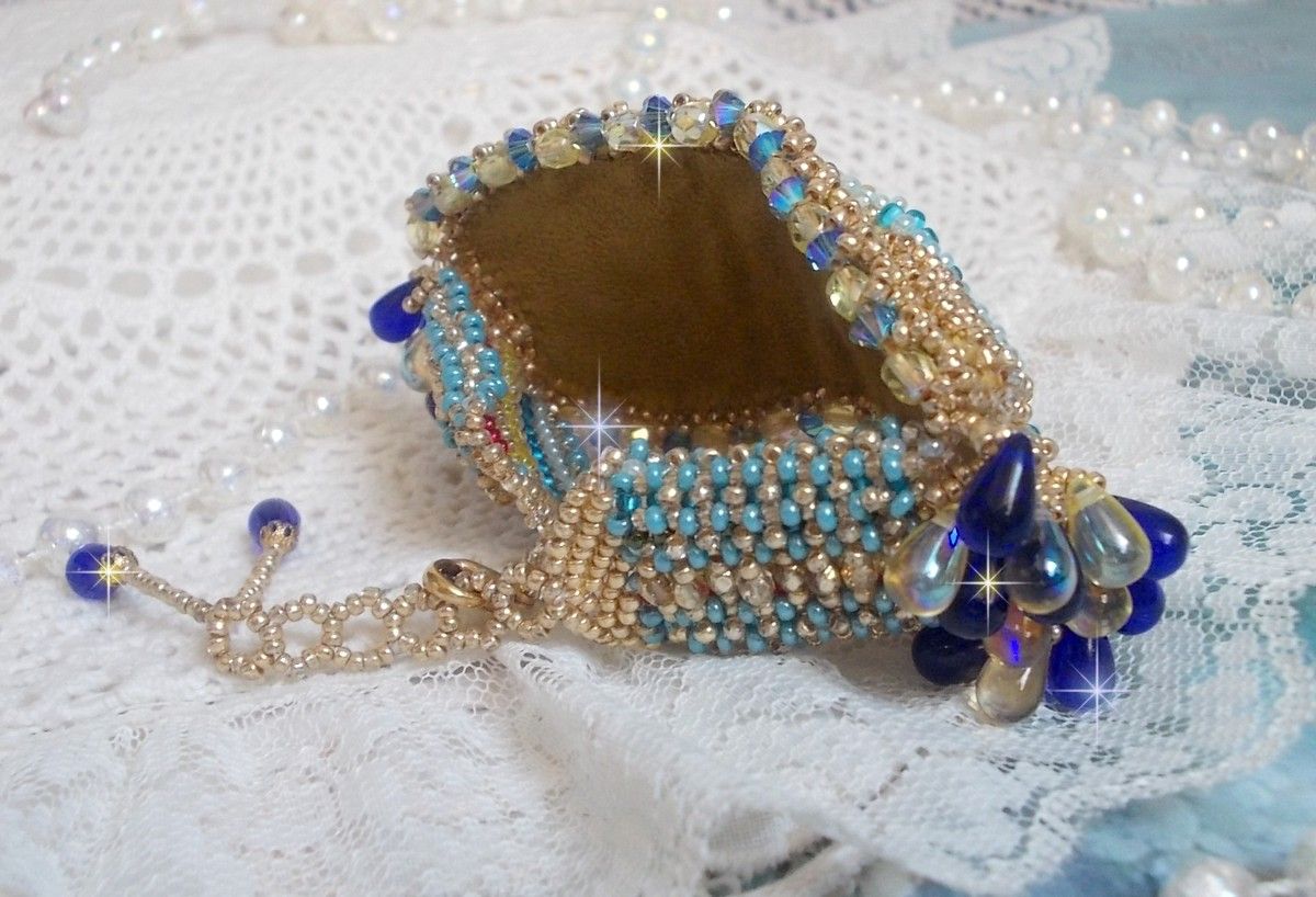 Pulsera Mariposa de Oro Azul bordada con cristales de Swarovski; gotas lisas, facetas, cuentas de semillas y un cierre de Oro Fino de 14 quilates