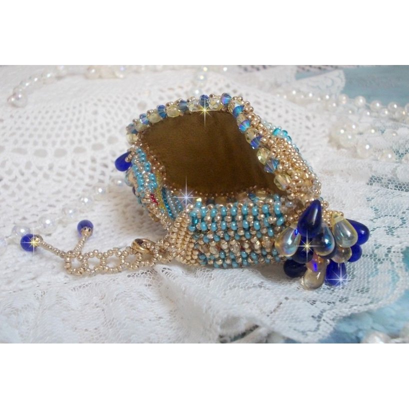 Pulsera Mariposa de Oro Azul bordada con cristales de Swarovski; gotas lisas, facetas, cuentas de semillas y un cierre de Oro Fino de 14 quilates