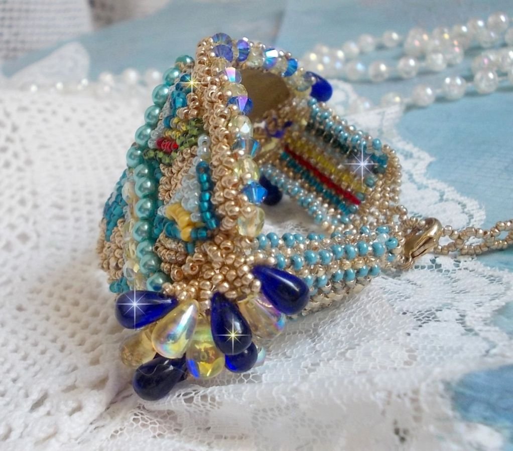 Pulsera Mariposa de Oro Azul bordada con cristales de Swarovski; gotas lisas, facetas, cuentas de semillas y un cierre de Oro Fino de 14 quilates