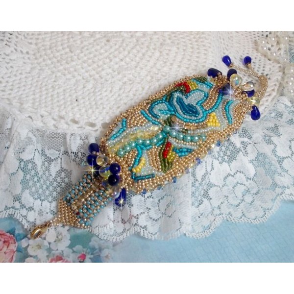 Pulsera Mariposa de Oro Azul bordada con cristales de Swarovski; gotas lisas, facetas, cuentas de semillas y un cierre de Oro Fino de 14 quilates