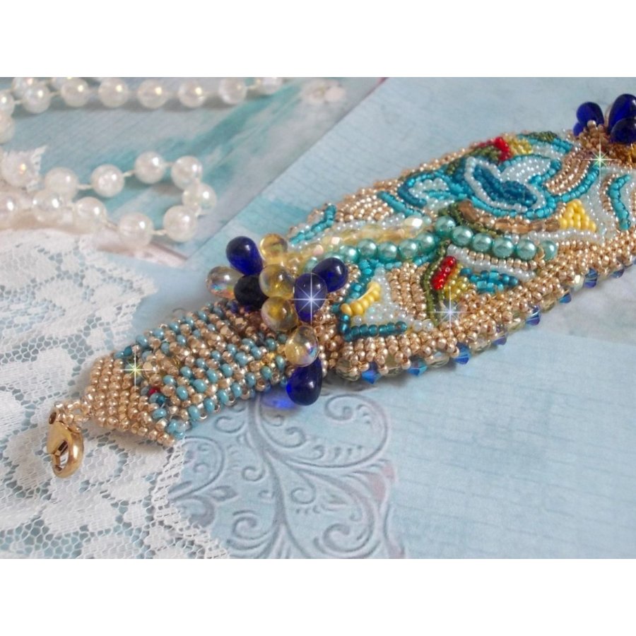 Pulsera Mariposa de Oro Azul bordada con cristales de Swarovski; gotas lisas, facetas, cuentas de semillas y un cierre de Oro Fino de 14 quilates