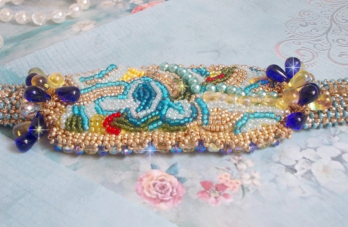 Pulsera Mariposa de Oro Azul bordada con cristales de Swarovski; gotas lisas, facetas, cuentas de semillas y un cierre de Oro Fino de 14 quilates