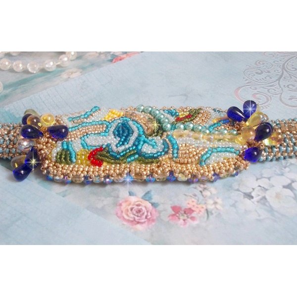 Pulsera Mariposa de Oro Azul bordada con cristales de Swarovski; gotas lisas, facetas, cuentas de semillas y un cierre de Oro Fino de 14 quilates