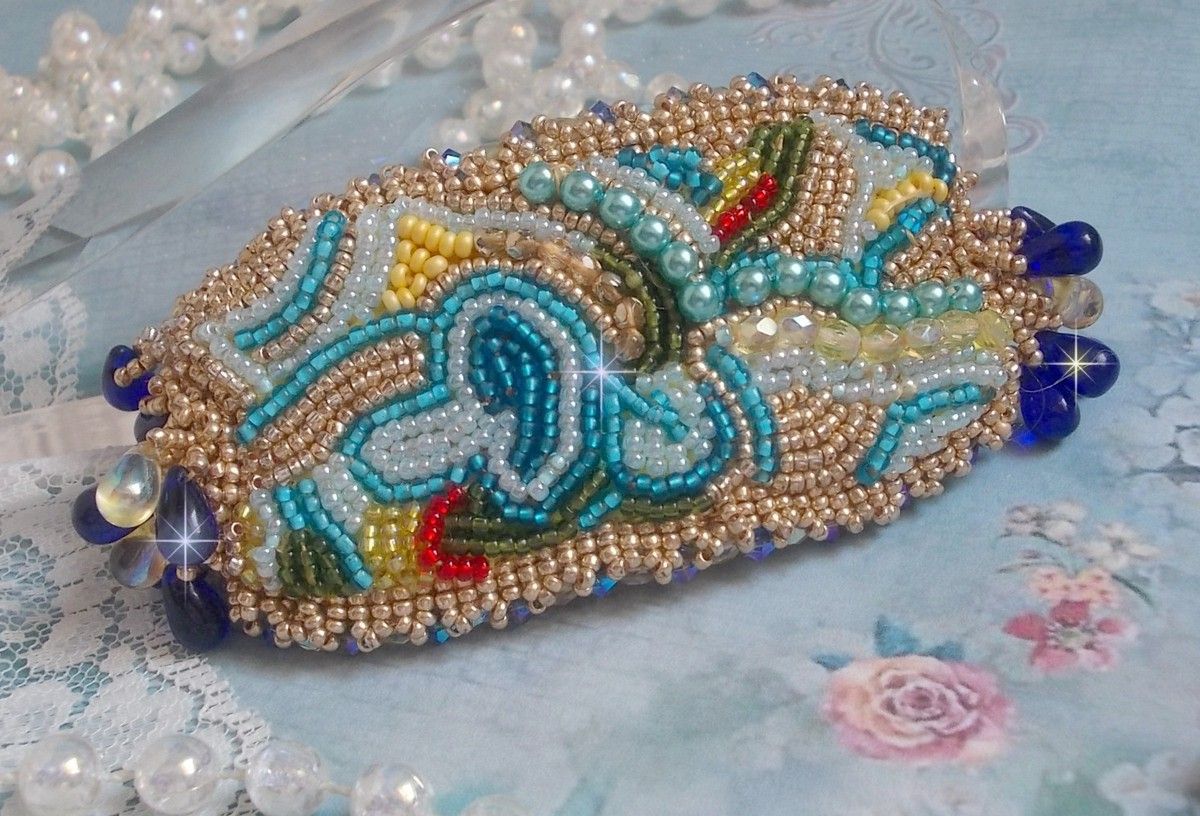 Pulsera Mariposa de Oro Azul bordada con cristales de Swarovski; gotas lisas, facetas, cuentas de semillas y un cierre de Oro Fino de 14 quilates