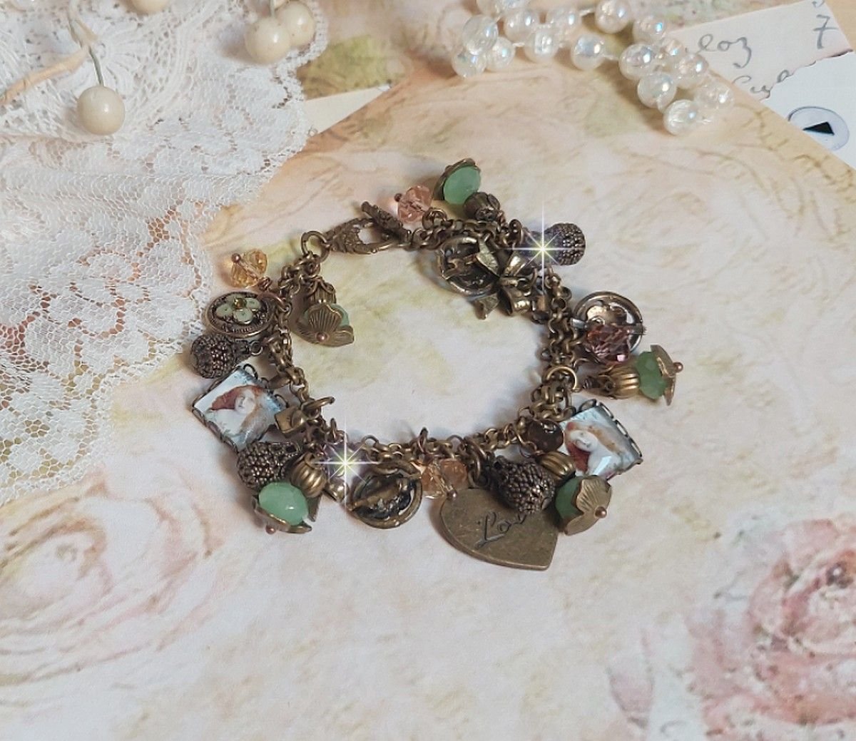 Bracelet Temps d’une Folie avec breloques : cœur, perles, gouttes filigranées, fleurs émaillées, perles rondes, cabochons carrés et perles rondes en Verre. Montés sur chaînes et fermoir en T Bronze