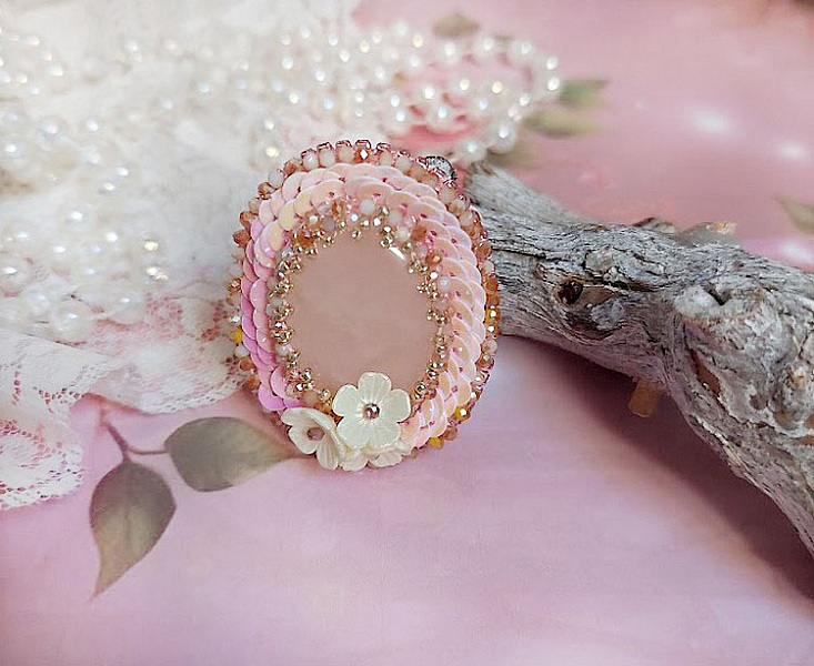 Sublimé par un jeu de sequins irisés, de perles rondes en verre scintillantes et de charmantes petites fleurs. 